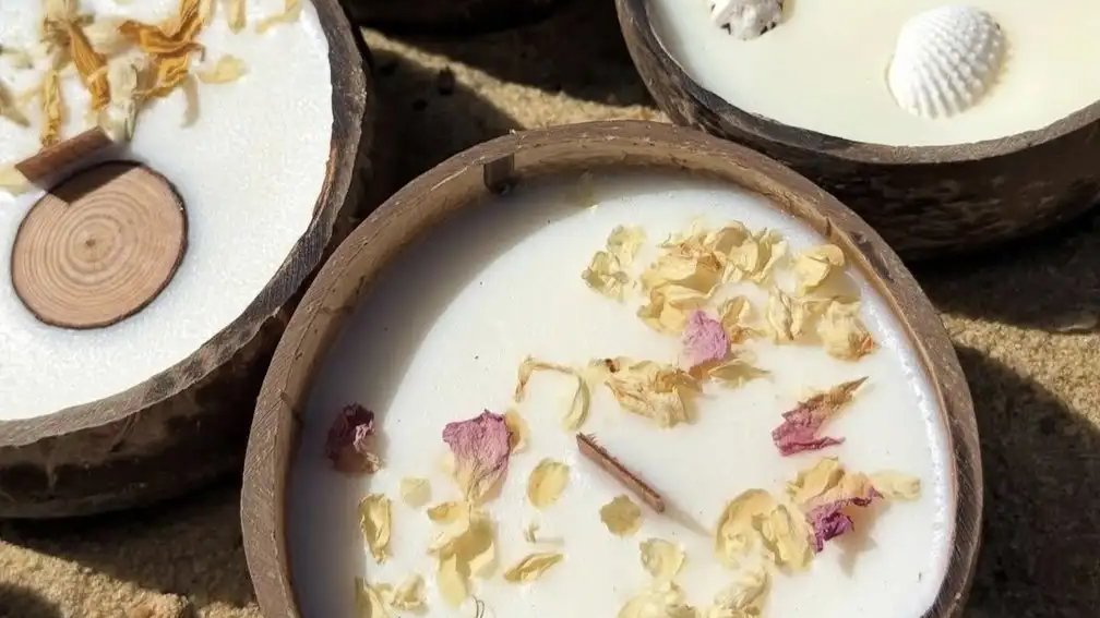 Quatre bougies parfumées Luminante en noix de coco vues de dessus, décorées de fleurs séchées