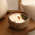 Bougie Luminante Bois de Oud allumée dans sa coque en noix de coco