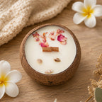 Bougie Luminante Fleur de Tiaré dans son contenant en noix de coco, pétales séchés et petits coquillages sur la cire