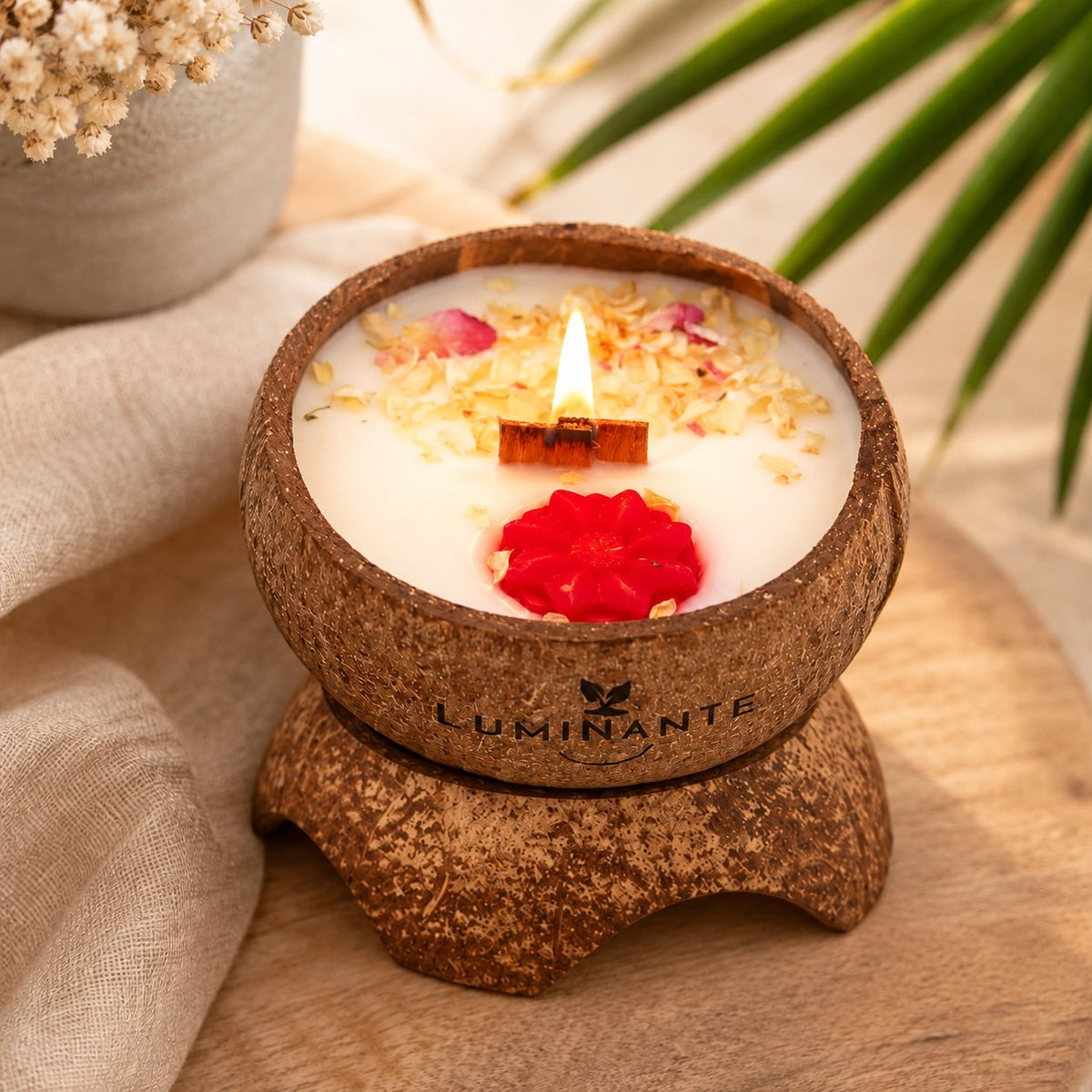 Bougie Luminante Lotus blanc coton allumée, pétales séchés et fleur de cire rouge sur le dessus