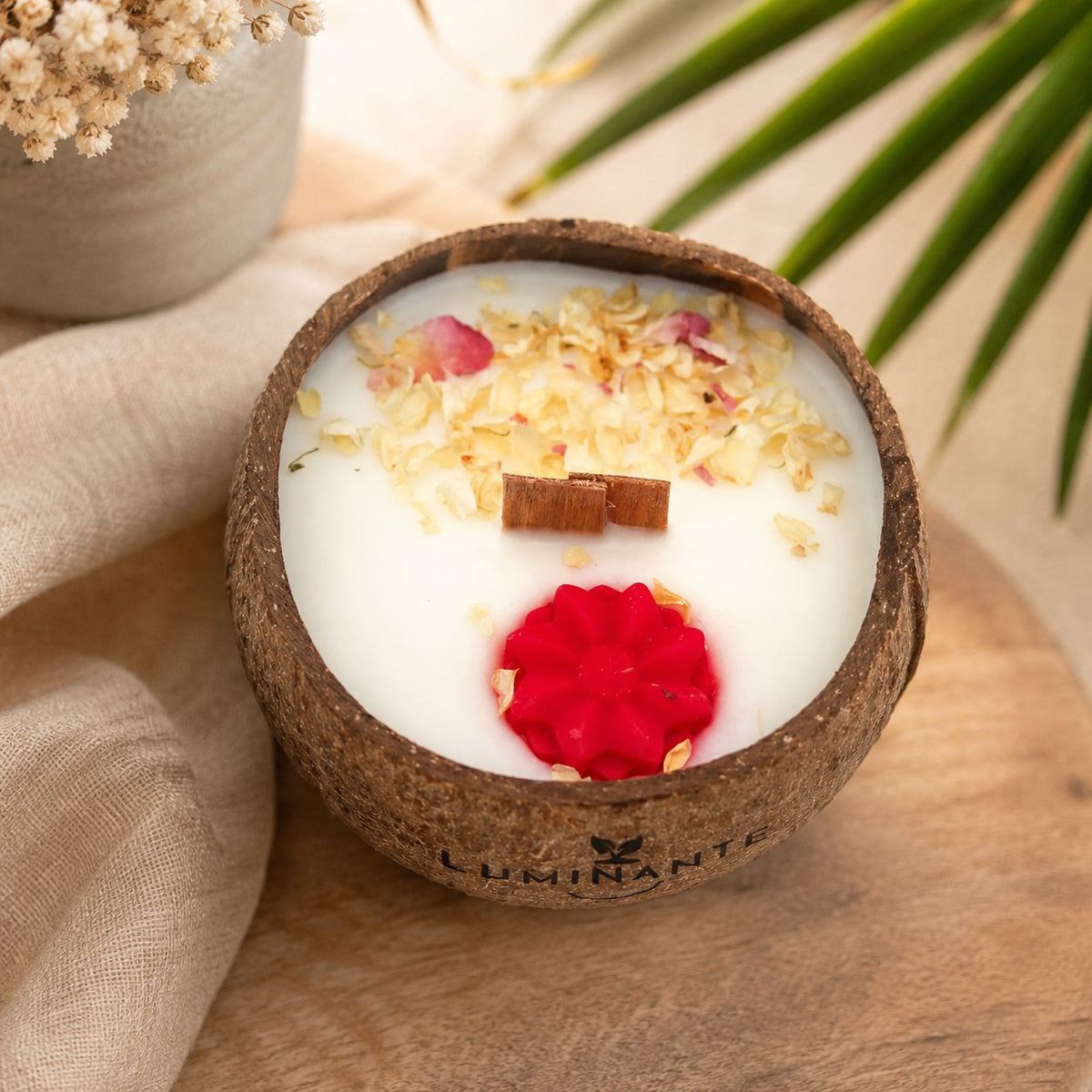 Bougie Luminante Lotus blanc coton dans son contenant en noix de coco, pétales séchés et fleur de cire rouge
