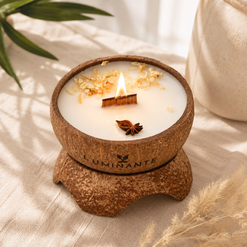 Bougie Luminante Vanille allumée avec une étoile de badiane et des pétales séchés sur la cire