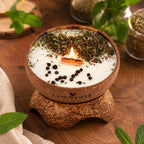 Bougie Luminante Verveine Menthe allumée, feuilles séchées et grains de poivre sur la cire