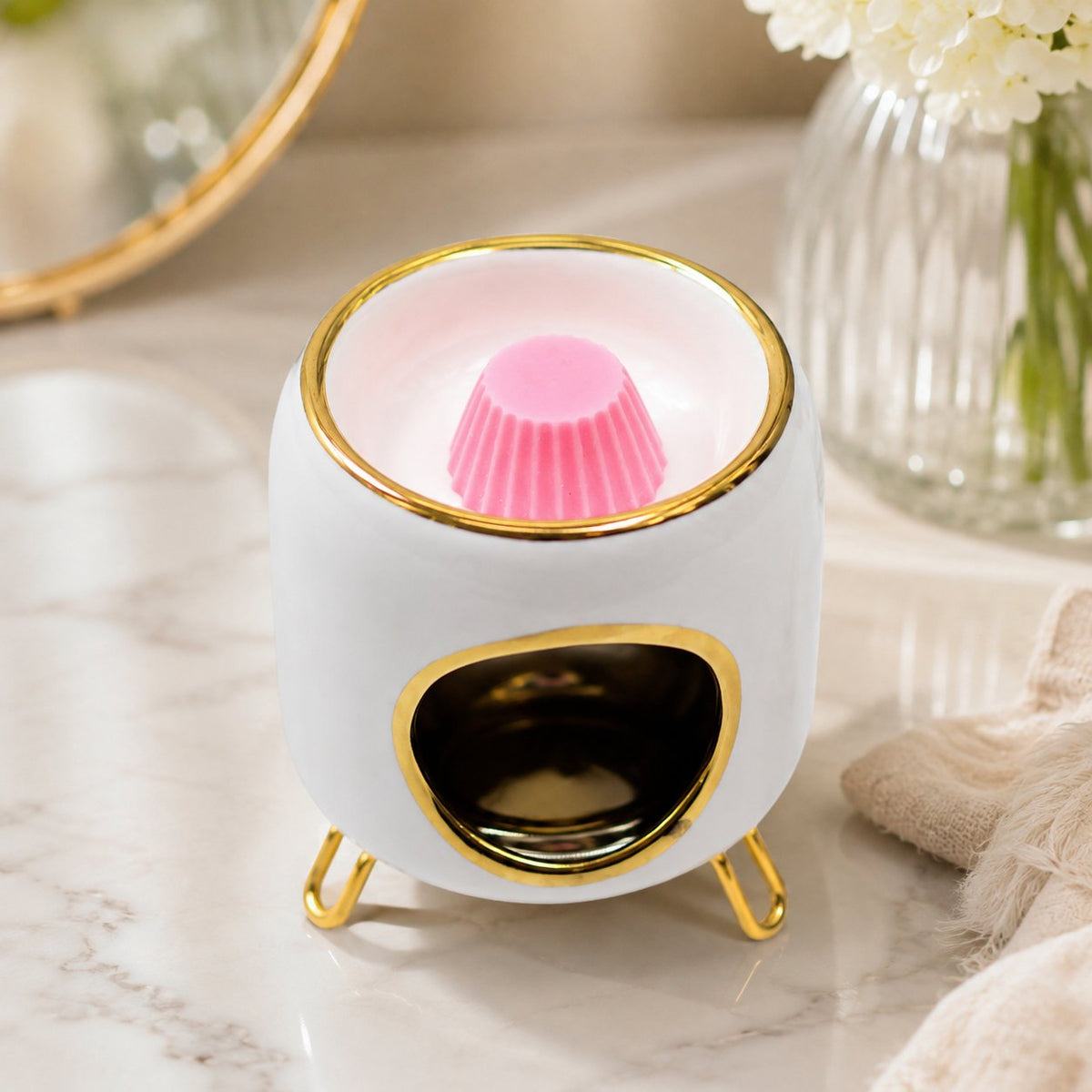 Brûle-parfum Luminante blanc avec un fondant parfumé rose dans sa coupelle