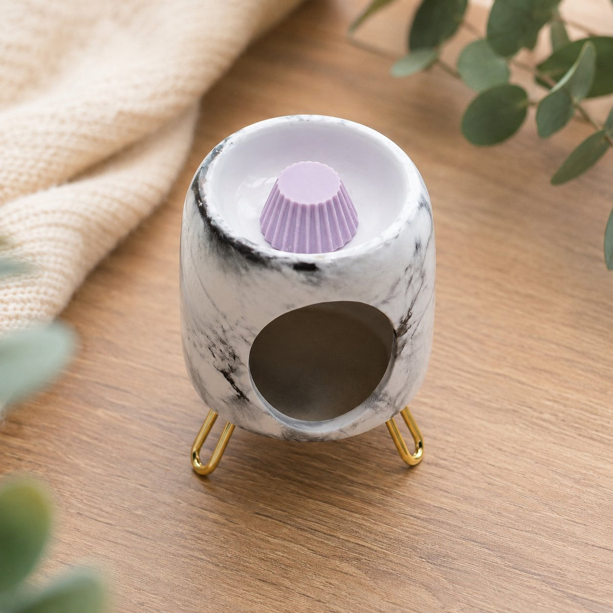 Brûle-parfum Luminante marbré avec un fondant parfumé mauve dans sa coupelle