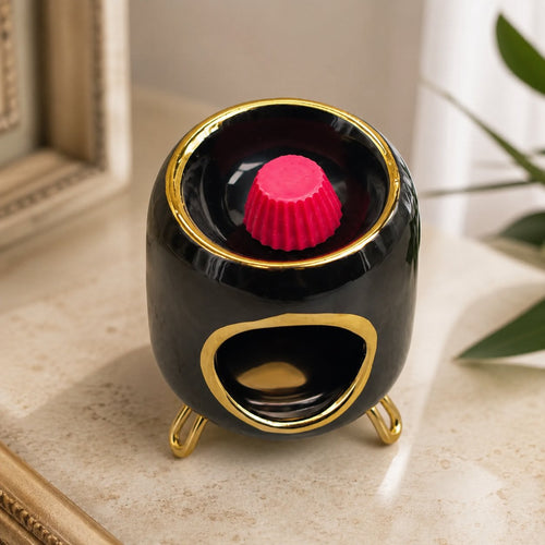 Brûle-parfum Luminante noir avec un fondant parfumé rose dans sa coupelle