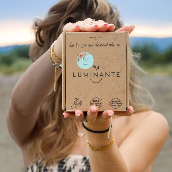 Femme tenant devant elle le coffret Luminante La bougie qui devient plante