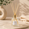 Diffuseur d'ambiance Luminante, flacon en verre à bouchon doré et bâtonnets en rotin