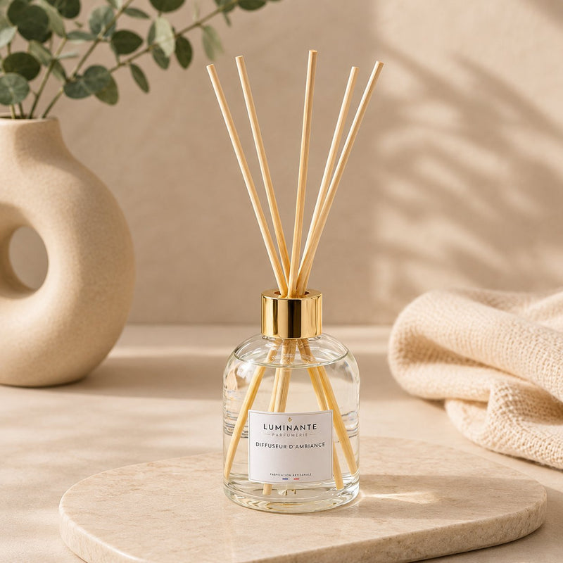 Diffuseur d'ambiance Luminante, flacon en verre à bouchon doré et bâtonnets en rotin