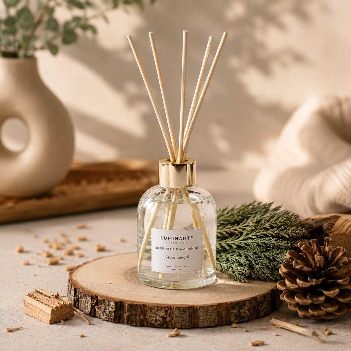 Diffuseur d'ambiance Luminante Cèdre poudré sur une rondelle de bois, avec branche de cèdre et pomme de pin