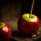 Deux pommes d'amour rouges brillantes sur un plateau en bois