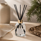 Diffuseur d'ambiance Luminante Cèdre poudré et ses bâtonnets, sur une table en bois clair