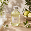 Recharge Luminante Fleur d'Oranger-Bergamote, flacon en verre entouré de fleurs d'oranger et d'agrumes