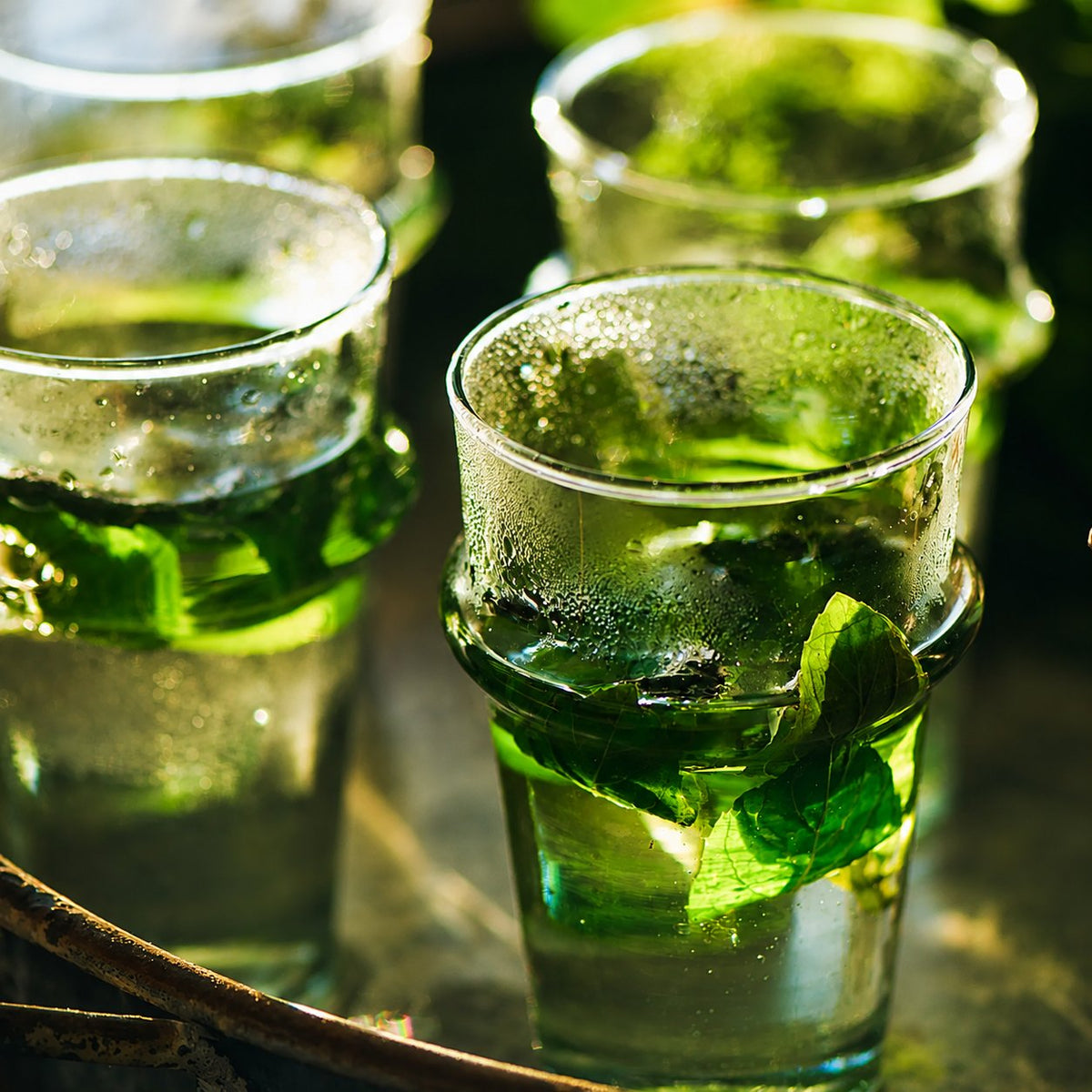 Verres de thé à la menthe fraîche posés sur un plateau