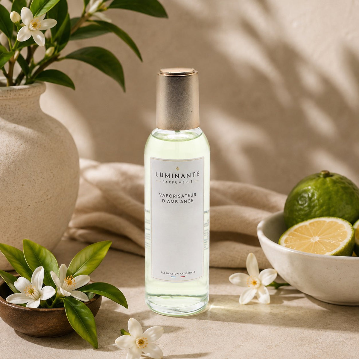 Vaporisateur d'ambiance Luminante Fleur d'Oranger-Bergamote, flacon entouré de fleurs d'oranger et d'agrumes